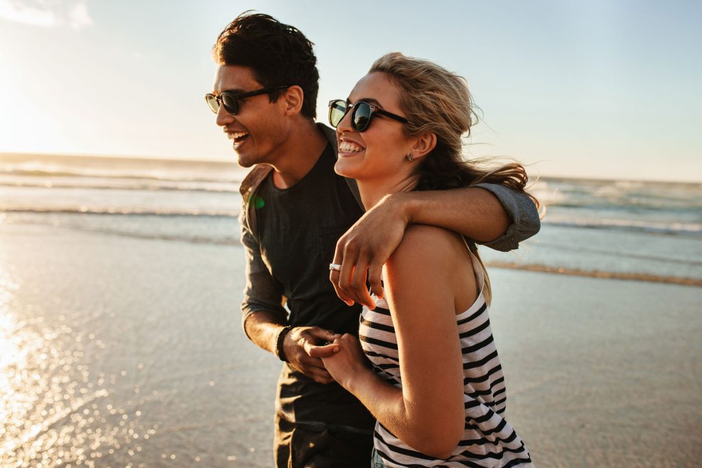 Couple walking along the beach at sunset