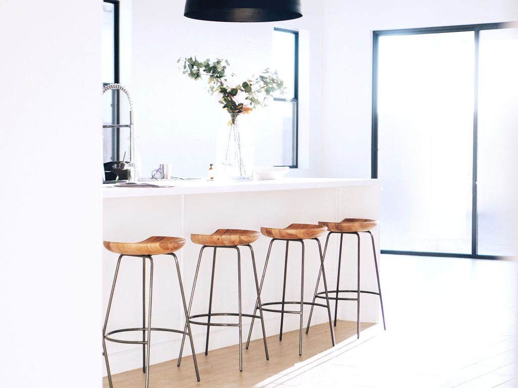 White kitchen island with timber bar stools
