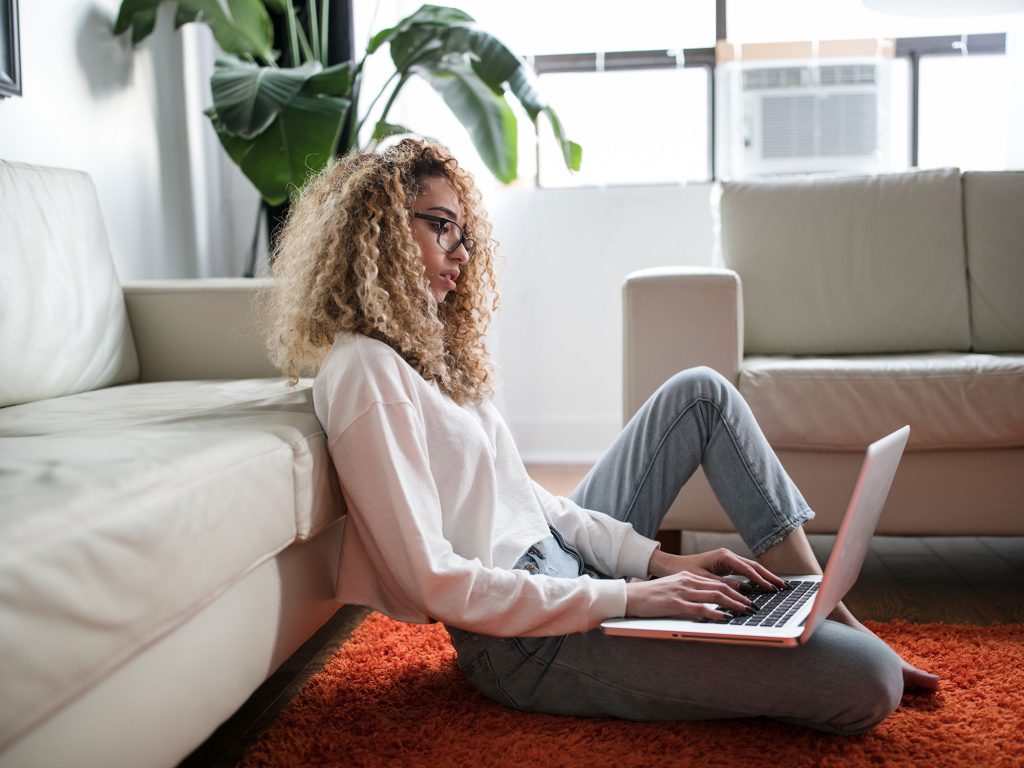 Woman working on a laptop in a bright living room